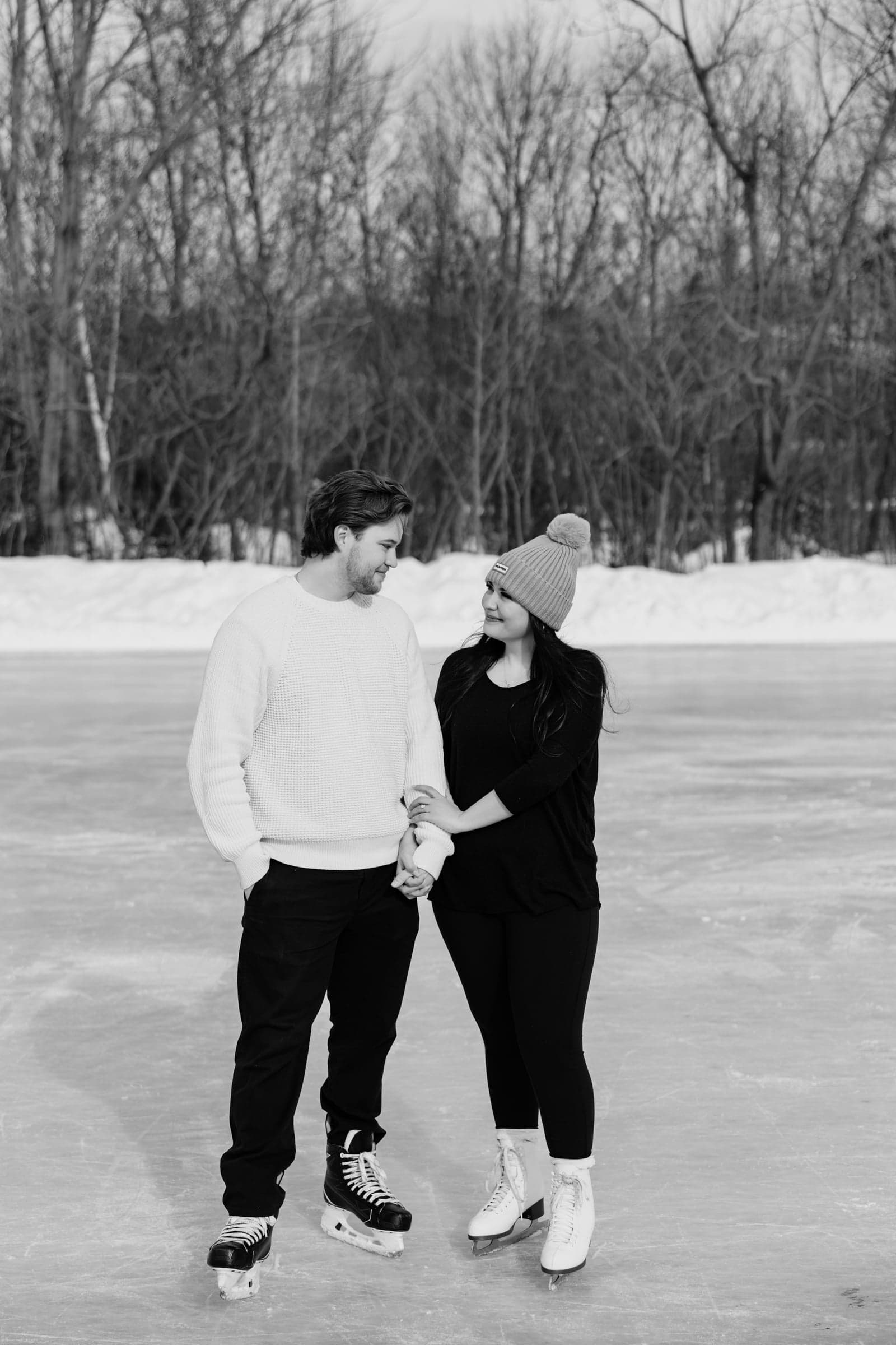 Victoria and Christoph holding hands on the ice, in black and white